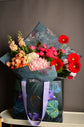 Red and pink flowers bouquet in bag
