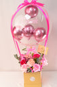 Pink flowers with balloons in box